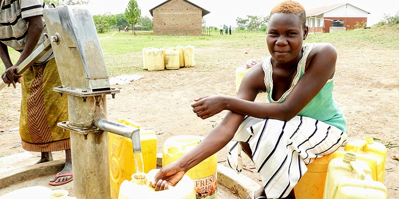 Women in Uganda pump water