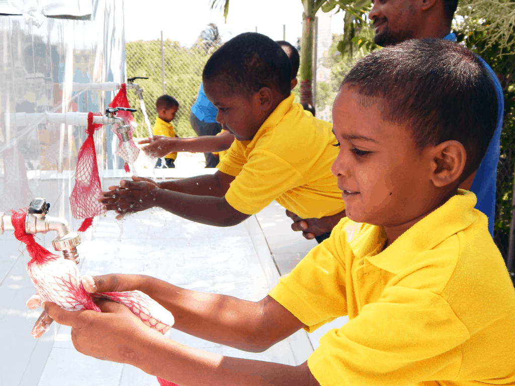 Boys use soap sacs to wash their hands at school in the Dominican Republic